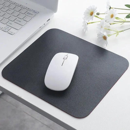 Small Mouse Pad in black next to a laptop